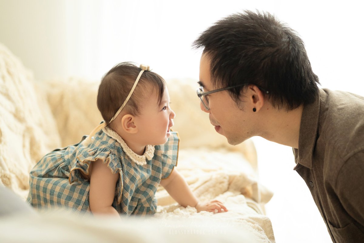 A heartwarming moment between a father and his baby during a Family Photography Sydney session at Blossom Brook Studio, capturing love and laughter in natural light.