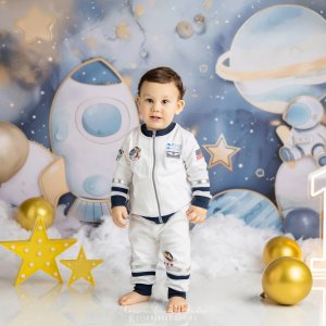 Adorable baby dressed as an astronaut during a space-themed First Birthday Photoshoot Sydney by Blossom Brook Studio, surrounded by planets, stars, and balloons.