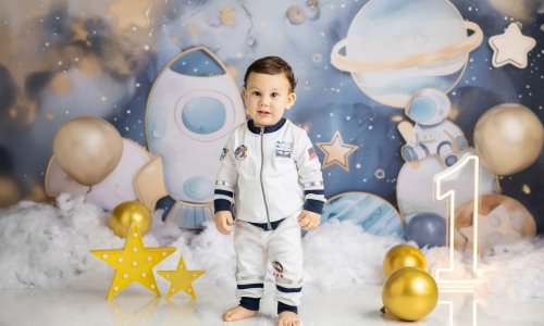 Newborn Photography Blog | Blossom Brook Studio 585 Adorable baby dressed as an astronaut during a space-themed First Birthday Photoshoot Sydney by Blossom Brook Studio, surrounded by planets, stars, and balloons.