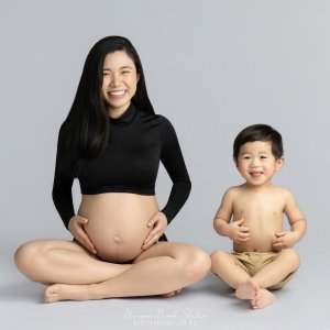 Pregnant woman with child, serene pose.
