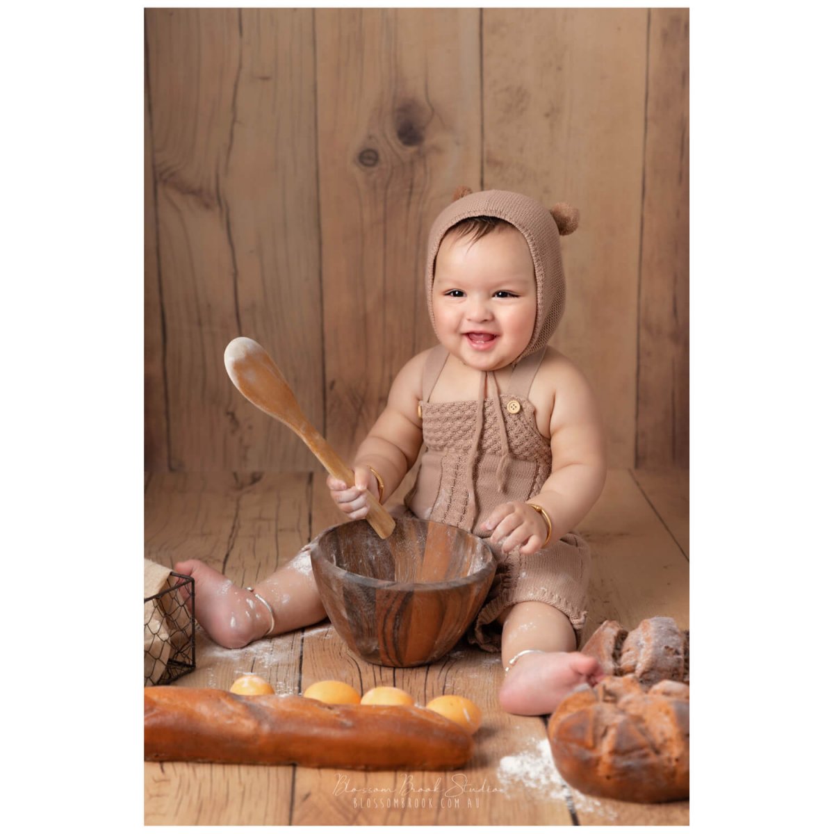 baby photoshoot in sydney baby boy in bear costume on wooden floor