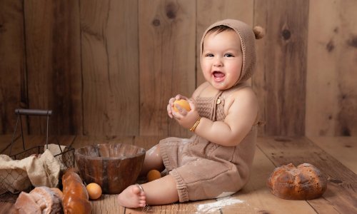 baby photos in sydney baby boy in bear costume on wooden floor