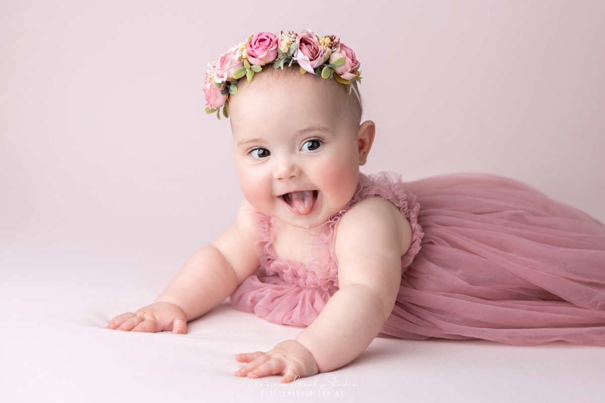 Beautiful baby girl in a pink dress and floral crown during a professional baby photography Sydney session by Blossom Brook Studio.