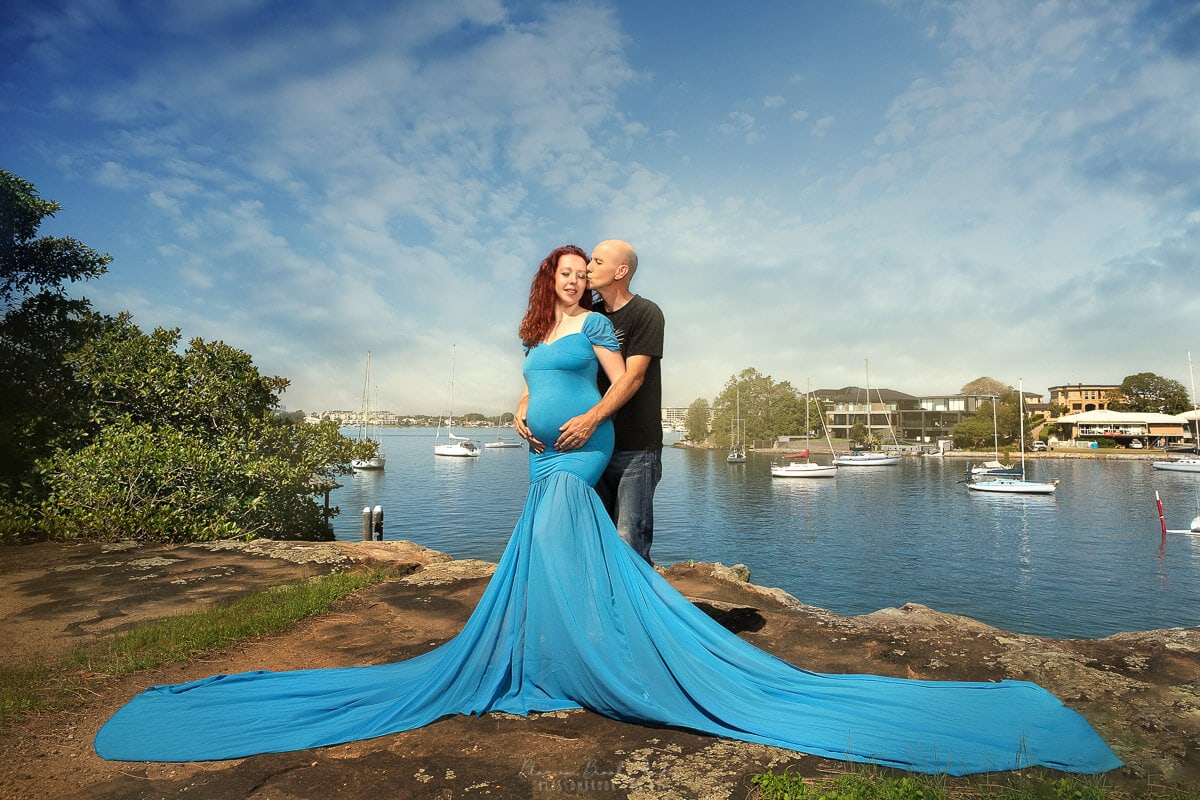 maternity outdoor photoshoot in blue dress water view