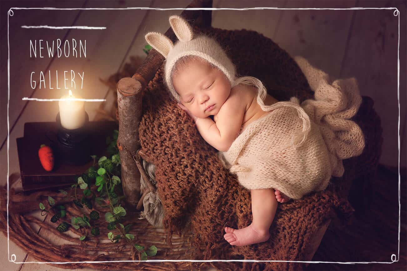 newborn baby in rabbit costume lying on a wooden bed with candle aside